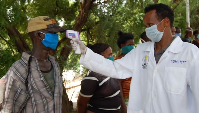 WORRIED: A health official in Garissa screens a pedestrian at the Garissa-Tana bridge
Image: /STEPHEN ASTARIKO