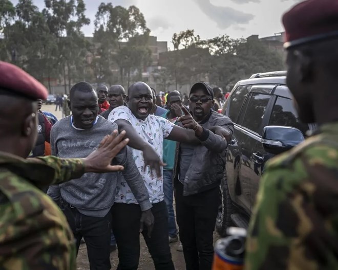 People argue with security forces trying to keep order after a few ballot boxes were discovered with their seals broken, at a tallying center in the Mathare area of Nairobi, Kenya Wednesday, Aug. 10, 2022. Kenyans are waiting for the results of a close presidential election in which the turnout was lower than usual.  BEN CURTIS / AP PHOTO