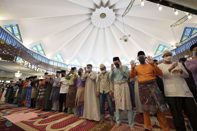 Muslims wearing protective masks pray at National Mosque in the morning of the Eid al-Fitr, marking the end the holy fasting month of Ramadan, in Kuala Lumpur, Malaysia, Monday, May 2, 2022. (AP Photo/Vincent Thian)